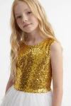 Vestido Riva blanco y dorado: cuerpo de lentejuelas doradas con cuello redondo, primer plano hasta la cintura