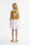 Vestido Riva blanco y dorado visto de espaldas: abertura, dos lazos de lentejuelas y falda blanca de tul