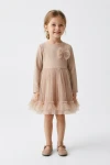 Vestido Iga beige de manga larga con lacito de tul, cuerpo entero de frente
