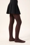 Leotardos marrón chocolate para niña en la modelo, vista lateral de pie con detalle de la puntera