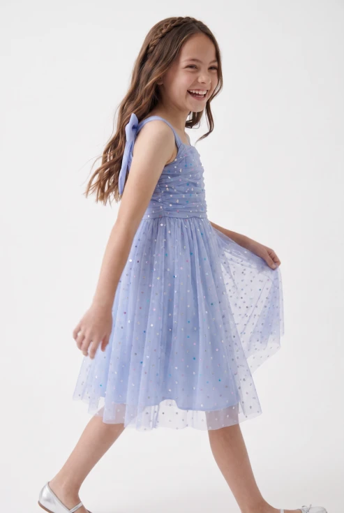 Vestido de tul Rina azul aciano claro con lentejuelas de colores: niña en movimiento, vista lateral