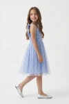 Vestido Rina azul aciano claro con lazo en el tirante y falda de tul, cuerpo entero de lado