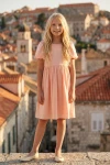 Vestido Sia rosa, cuerpo entero de frente con el casco antiguo de fondo