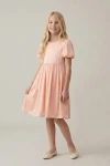 Vestido Sia rosa por la rodilla, cuerpo entero de frente sobre fondo de estudio