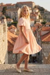 Vestido Sia rosa visto de lado con los tejados del casco antiguo al fondo
