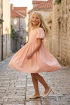 Vestido Sia rosa girando en una calle empedrada del casco antiguo