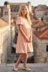 Vestido Sia rosa, cuerpo entero con una torre del casco antiguo al fondo