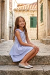 Vestido Harper azul cielo en exterior, niña sentada