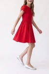 Vestido Rumi rojo con la falda en movimiento, encuadre hasta los pies