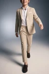Traje Liam beige para niño con la americana abierta, en movimiento de frente