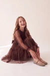 Vestido Holly marrón con falda de tul y lazo en la cintura, niña sentada