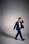 Traje Sam azul marino para niño con pajarita negra, niño en movimiento con la americana abierta