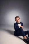 Traje Sam azul marino para niño con pajarita negra, niño sentado en el suelo, vista frontal