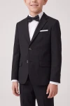 Americana del traje Sam negro para niño con pajarita, primer plano de solapas, botones y bolsillos